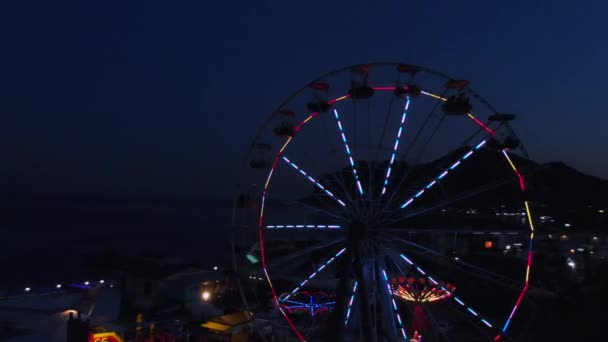 Riesenrad auf dem Hintergrund des Meeres bei Sonnenuntergang. Blick von oben — Stockvideo