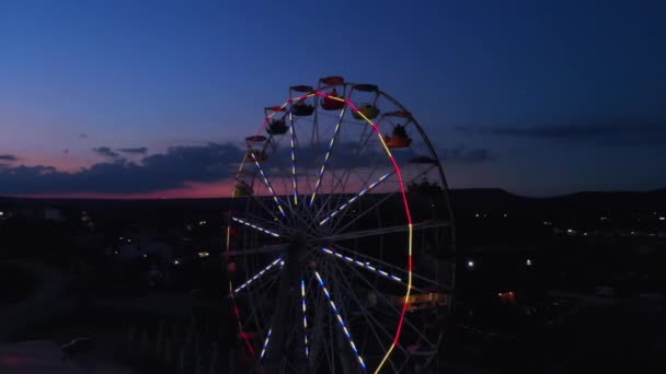 Reuzenrad op de achtergrond van de zee bij zonsondergang. Van bovenaf bekijken — Stockvideo