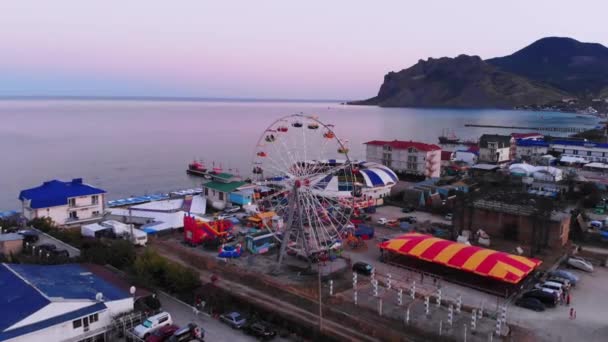 Ferris Wheel on the Background of the Sea at sunset. View from above — Stock Video