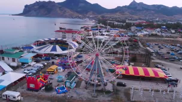 Ferris Wheel on the Background of the Sea at sunset. View from above — Stock Video