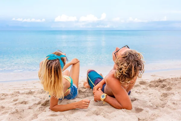 Retrato de pareja joven enamorada en la playa y disfrutando del tiempo juntos. Pareja joven divirtiéndose en una costa arenosa . —  Fotos de Stock
