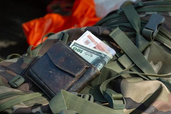 Corruption concept. Money of different countries in a wallet placed on a military uniform — Stock Photo, Image