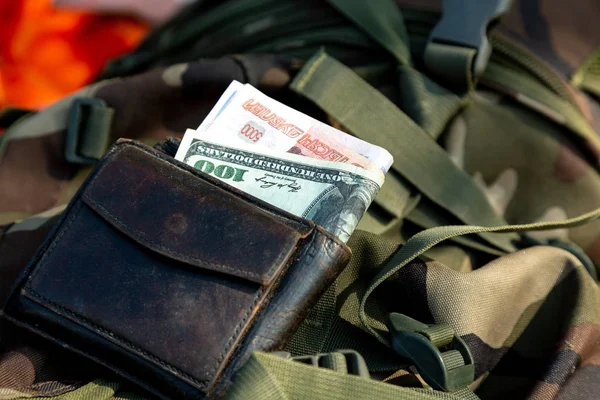 Pojem korupce. Peníze z různých zemí v pouzdře umístěna na vojenské uniformě — Stock fotografie