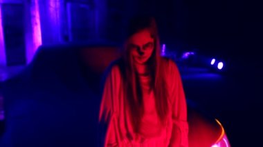 Ölü Gelin Makyaj için Halloween mor ışıklı terk edilmiş evde karanlıkta gelin elbiseli Genç kadınla. Akşam saat ile vurdu eski olası hayaletler perili evi terk