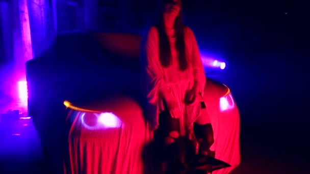 Femme avec mariée morte maquillage pour Halloween debout près de la voiture dans la robe de mariée blanche dans le noir à la maison abandonnée — Video