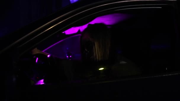 Frau mit totem Brautschminke zu Halloween sitzt im Auto im weißen Brautkleid in der Dunkelheit. — Stockvideo