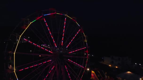 Riesenrad auf dem Hintergrund des Meeres bei Sonnenuntergang. Blick von oben — Stockvideo