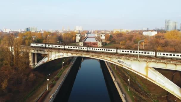 Trainen op een brug gaan over Canalagainst van de achtergrond van de herfst landschap — Stockvideo