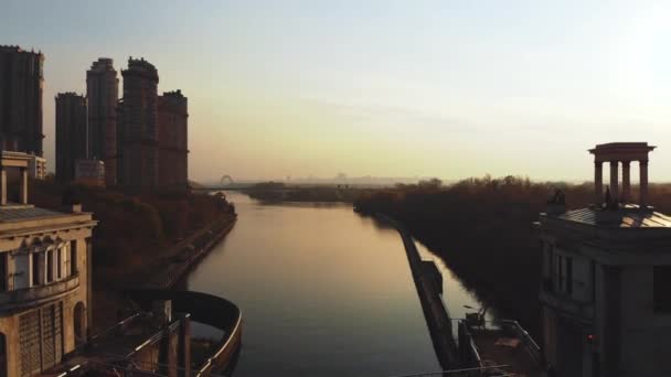 Vista aérea del río y la gran ciudad al atardecer. Volando sobre rascacielos y río — Vídeos de Stock