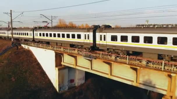 Поезд на мосту, идущем через Канальный на фоне осеннего пейзажа — стоковое видео