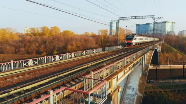 Zug auf einer Brücke über Kanal vor der Kulisse der herbstlichen Landschaft — Stockvideo