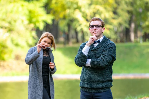 Pareja hablando en serio al aire libre en un parque con un fondo verde — Foto de Stock