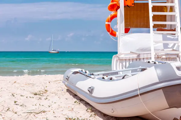 Tiro da bela praia tropical em um dia ensolarado de verão, com um lugar de salva-vidas e barco estacionado à beira-mar — Fotografia de Stock