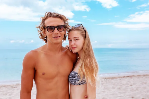 Sonriente joven pareja juguetona enamorada divirtiéndose en la playa de arena . —  Fotos de Stock