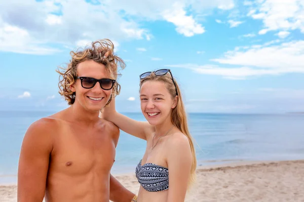 Χαμογελώντας παιχνιδιάρικο νεαρό ζευγάρι στην αγάπη, έχοντας διασκέδαση στην παραλία. — Φωτογραφία Αρχείου