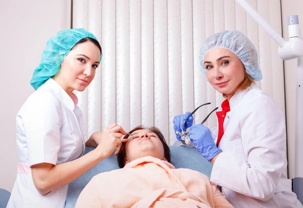 Dwie kobiety lekarze badanie pacjenta po operacji plastycznej — Zdjęcie stockowe