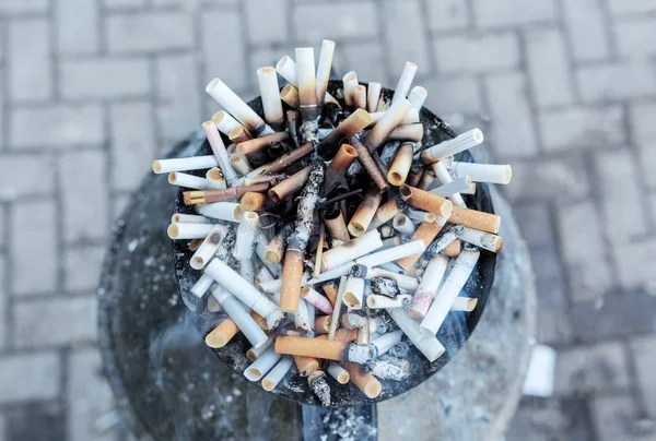Rabos de cigarro no cinzeiro. Close up monte de muitos fumar cigarros stubs, beatas de cigarro em cinzeiro — Fotografia de Stock