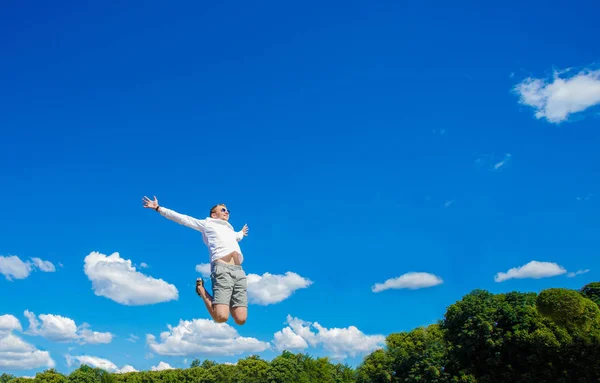Kerl schwebt in der Luft. der Kerl schwebt in der Luft vor dem Hintergrund einer Fontäne — Stockfoto
