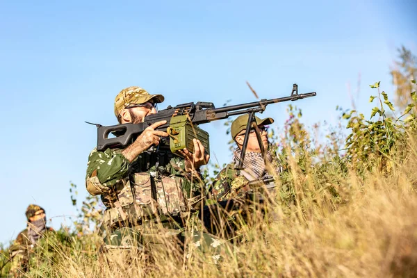 Sniper tým vyzbrojeni velkorážná děla, sniper puška, Střelba nepřátelské cíle na škále od přístřeší, sedí v záloze — Stock fotografie