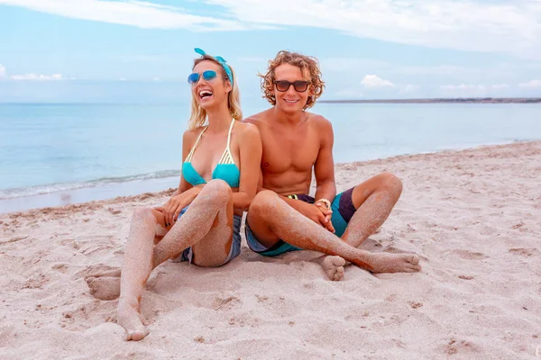 Ritratto di giovane coppia innamorata in spiaggia e che si gode il tempo insieme. Giovane coppia si diverte su una costa sabbiosa . — Foto Stock
