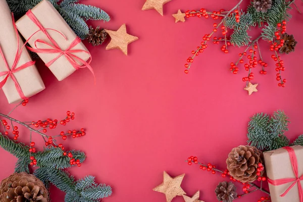 Composición navideña. Decoraciones rojas de Navidad, ramas de abeto con cajas de regalo de juguetes sobre fondo rojo. Plano, vista superior, espacio para copiar — Foto de Stock