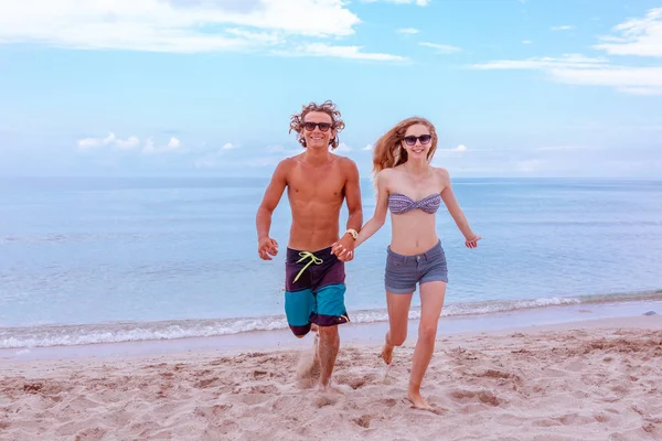 Молода пара закохана на пляжі і насолоджується перебуванням разом, бігає на пляжі — стокове фото