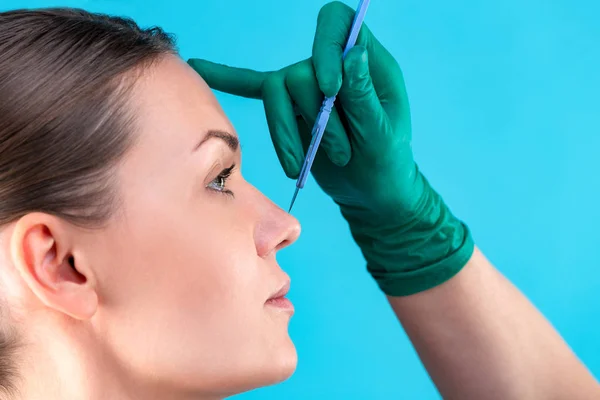 Chirurg kosmetyczny badanie kobiety klienta w biurze. Lekarz sprawdzanie womans twarz, nos przed chirurgii plastycznej. Chirurg lub kosmetyczka ręce dotykając twarz kobiety. Korekcja nosa — Zdjęcie stockowe