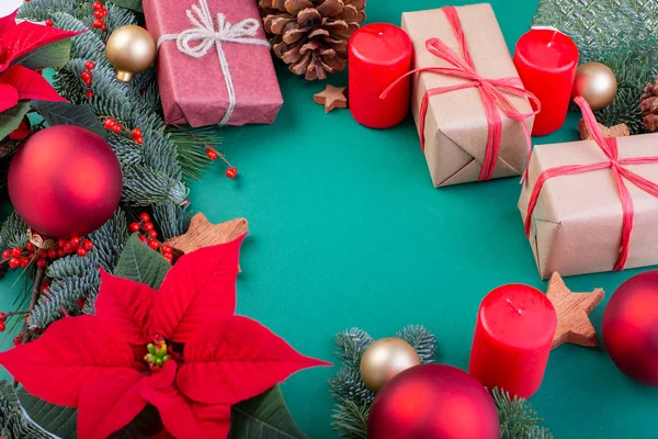 Christmas composition. Christmas green decorations, fir tree branches with toys gift boxes on green background. Flat lay, top view, copy space