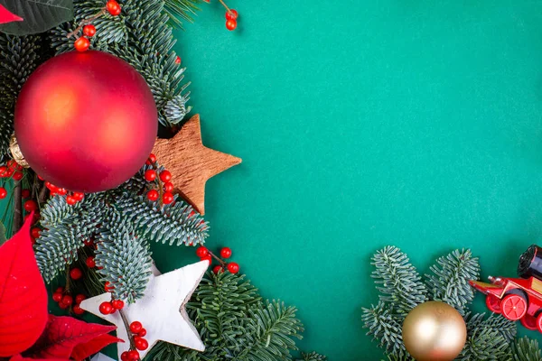 Christmas composition. Christmas green decorations, fir tree branches with toys gift boxes on green background. Flat lay, top view, copy space