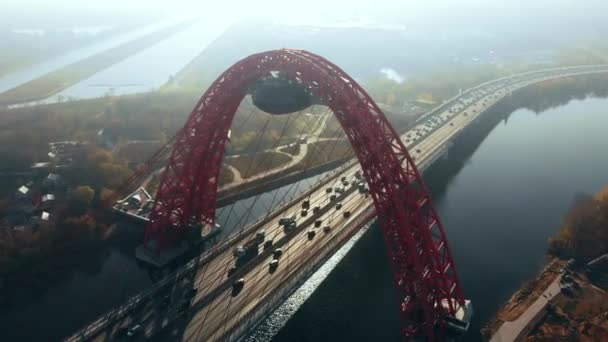 Αεροφωτογραφία από το εμβληματικό ορόσημο που είναι γραφική γέφυρα που διασχίζει τον ποταμό Μόσχα στη Μόσχα. Κυκλοφορία αυτοκινήτων στο καλώδιο-μένοντη γέφυρα του κόκκινου χρώματος στο χρόνο ημέρας. 4k. — Αρχείο Βίντεο