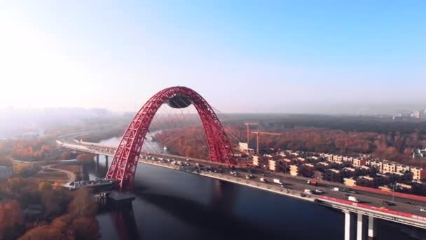 Vue aérienne du monument emblématique qu'est le Pont pittoresque qui traverse la rivière Moscou à Moscou. Trafic de voitures sur le pont à haubans de couleur rouge le jour. 4K . — Video