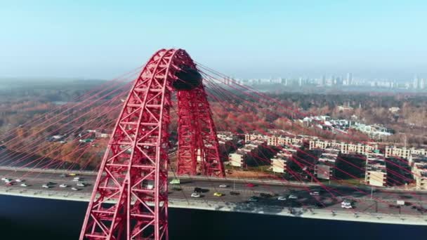 Vue aérienne du monument emblématique qu'est le Pont pittoresque qui traverse la rivière Moscou à Moscou. Trafic de voitures sur le pont à haubans de couleur rouge le jour. 4K . — Video