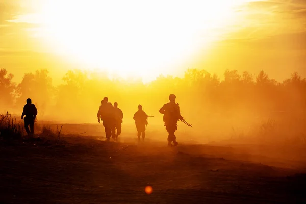 Silhouet actie soldaten wandelen houd wapens is de achtergrond rook en zonsondergang en wit saldo schip effect donkere kunststijl — Stockfoto