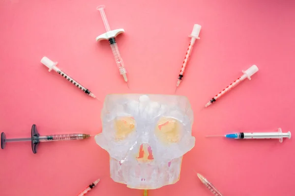 Colocación plana de instrumentos médicos con cráneo humano sobre fondo rosa. Preparar la atención médica antecedentes médicos . —  Fotos de Stock