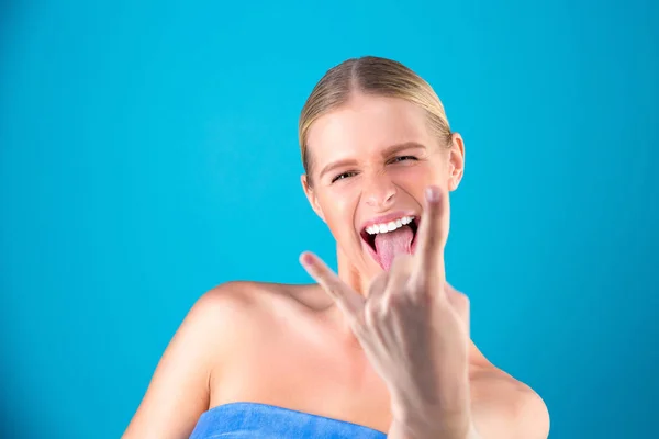 Close up portrait of Beautiful model girl on blue background show tongue out and shows a gesture with his hands Rock n Roll. The concept of body language — Stock Photo, Image