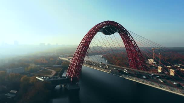 Vue aérienne du monument emblématique qu'est le Pont pittoresque qui traverse la rivière Moscou à Moscou. Trafic de voitures sur le pont à haubans de couleur rouge le jour. 4K . — Video