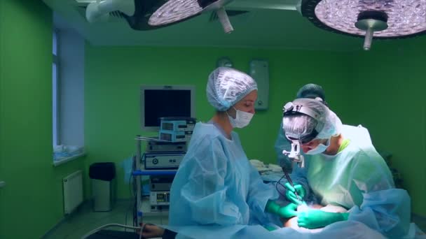 Chirurg en chirurgisch team zijn het uitvoeren van cosmetische chirurgie op borsten in ziekenhuis operatiekamer. Borstvergroting. Mammoplastiek. De uitbreiding van de borst. Chirurgie detail. — Stockvideo