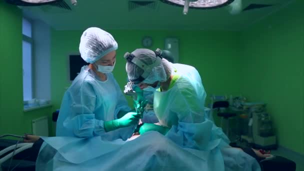 Cirurgião e equipe cirúrgica estão realizando cirurgia estética em mamas no centro cirúrgico do hospital. Aumento da mama. Mamoplastia. Ampliação mamária. Detalhe da cirurgia . — Vídeo de Stock