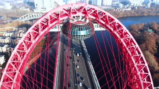 Vue aérienne du monument emblématique qu'est le Pont pittoresque qui traverse la rivière Moscou à Moscou. Trafic de voitures sur le pont à haubans de couleur rouge le jour. 4K . — Video