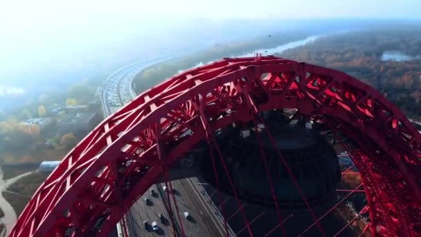 Aerial view of the iconic landmark that is Picturesque Bridge which crosses the Moscow River in Moscow. Cars traffic on cable-stayed bridge of red color at day time. 4K. — Stock Video