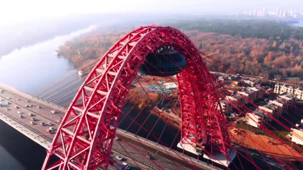 Moskova'da Moskova Nehri geçerek Picturesque köprü ikonik simgesel yapı hava görünümünü. Gün zaman kırmızı renk askılı köprüde araba trafik. 4k. — Stok video