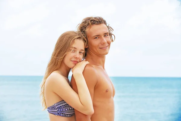 Retrato de pareja joven enamorada en la playa y disfrutando del tiempo juntos. Pareja joven divirtiéndose en una costa arenosa . — Foto de Stock