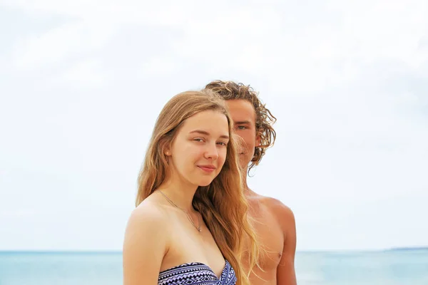 Retrato de pareja joven enamorada en la playa y disfrutando del tiempo juntos. Pareja joven divirtiéndose en una costa arenosa . —  Fotos de Stock