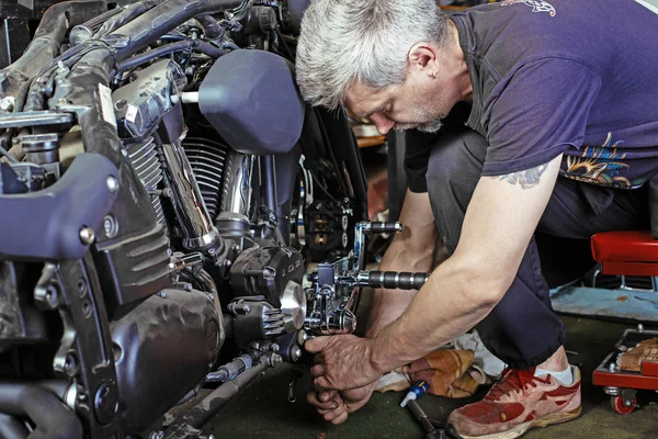 Yan görünümü motosiklet tamiri garajda çalışan adam portresi — Stok fotoğraf