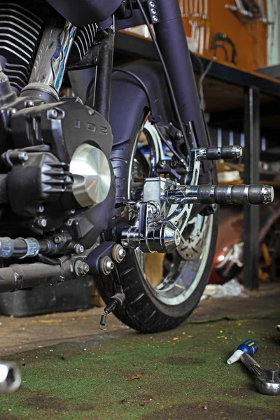 Bijgesneden close-up shot van mooie en op maat gemaakte motorfiets in de werkplaats — Stockfoto