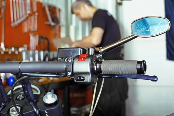 Side view portrait of man working in garage repairing motorcycle — Stock Photo, Image