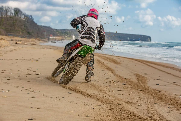 Motorradfahrer im Schutzanzug sitzt auf Motorrad vor dem Meer — Stockfoto