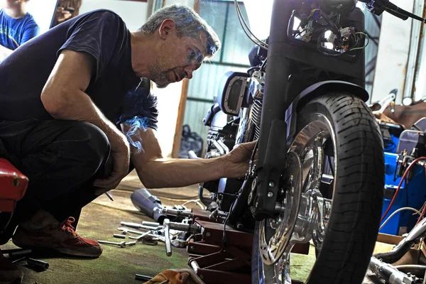 Yan görünümü motosiklet tamiri garajda çalışan adam portresi — Stok fotoğraf