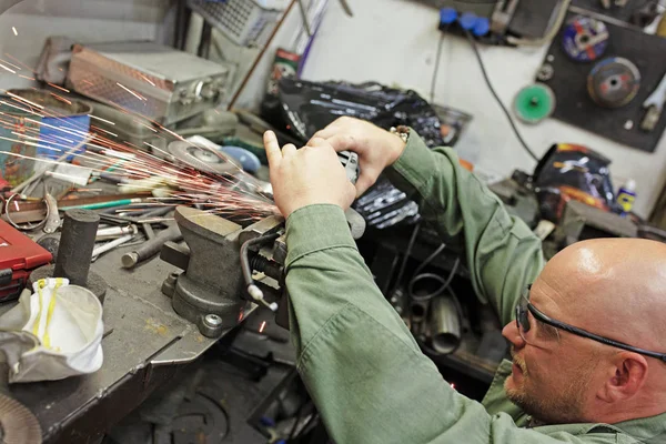 Tung industriarbetare skär stål med vinkelslip vid bilservice — Stockfoto