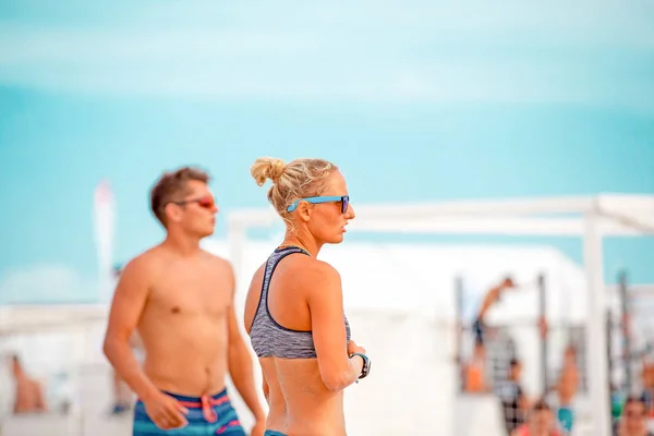 Voleibol de praia. Bola de jogo sob a luz solar e céu azul. Grupo de jogadores de praia de voleibol se preparando para jogar na praia . — Fotografia de Stock